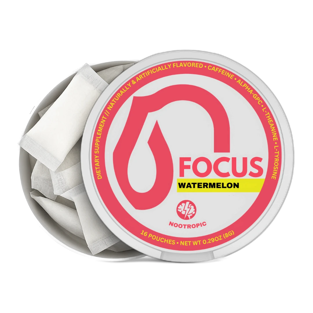 An open round metal tin of Nootropics Focus Watermelon dietary supplement, showing white single-serve pouches inside. The lid features a white label with a prominent pink droplet logo, the word 'FOCUS' in pink, a yellow 'WATERMELON' banner, and the Nootropics logo at the bottom.